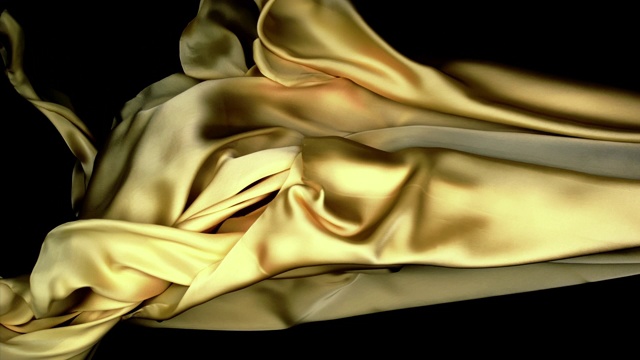 金属银色和金色的丝质织物在超慢的动作中横向流动和摆动，近景，黑色背景视频下载