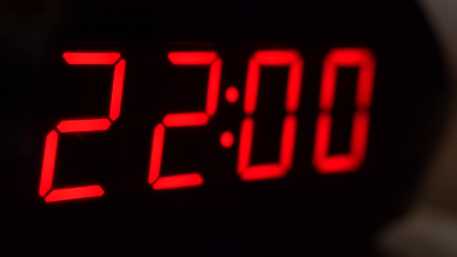 黑色数字时钟屏幕特写显示22.00。黑色背景上闪烁的数字。现代计时器和红色霓虹灯，电子设备和现代技术视频下载