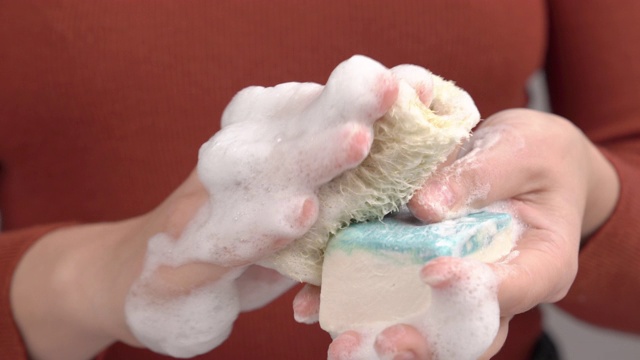 天然有机皂的使用。泡沫毛巾的特写。皮肤护理的概念。孤立的，选择性聚焦拍摄视频下载