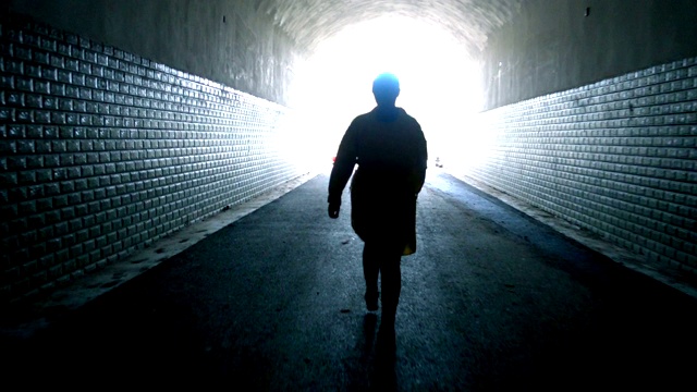 一个女人穿过黑暗的隧道视频素材