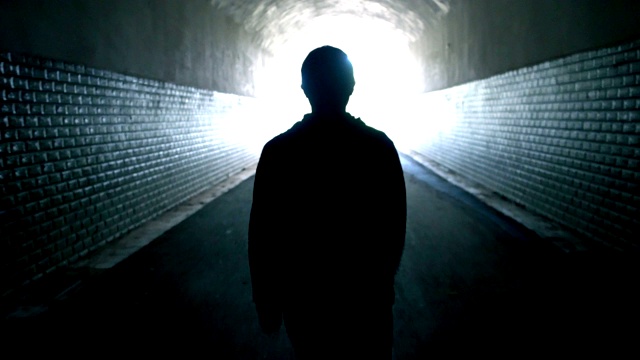 一个女人穿过黑暗的隧道视频素材