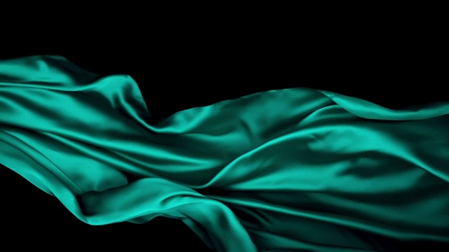金属绿色丝质织物在超慢的动作中横向流动和摆动，近距离，黑色背景视频素材