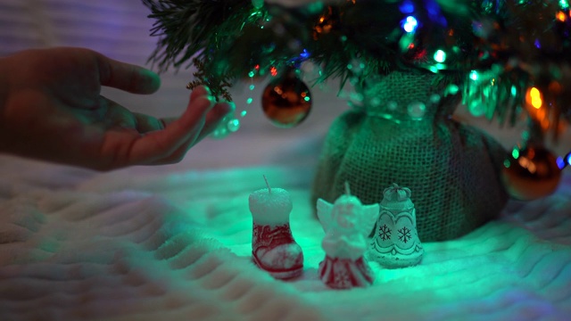 圣诞快乐和新年快乐的概念。闪亮的圣诞灯，魔法球和玩具装饰。女人的手触摸着圣诞饰品。闪闪发光的圣诞树视频素材