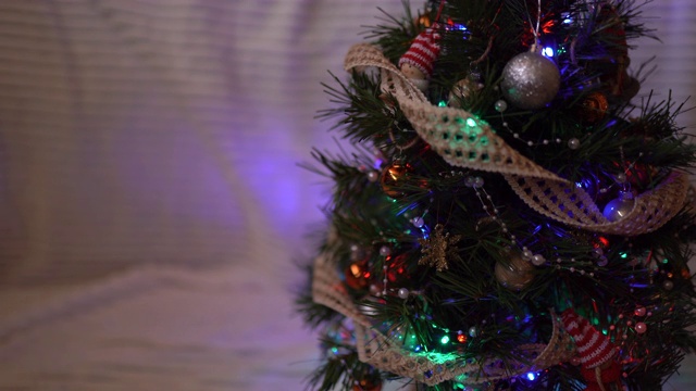 令人惊叹的装饰圣诞树与闪闪发光的彩色花环在白色的背景。闪闪发光的灯和魔法球装饰着圣诞树。圣诞快乐，恭贺新禧视频素材