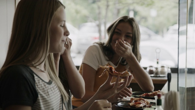 在美国犹他州普罗沃，快乐的女孩吃披萨片的特写视频素材