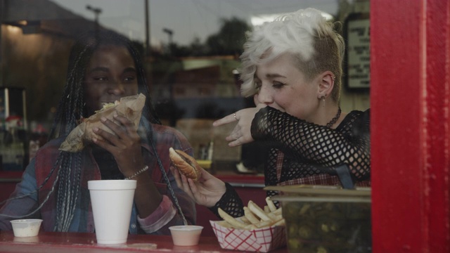 美国犹他州普罗沃，朋友们在咖啡馆的窗口边吃三明治边聊天视频素材