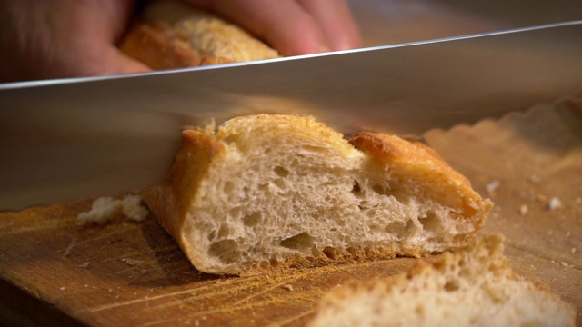 新鲜的面包被切成薄片放在木板上。视频下载