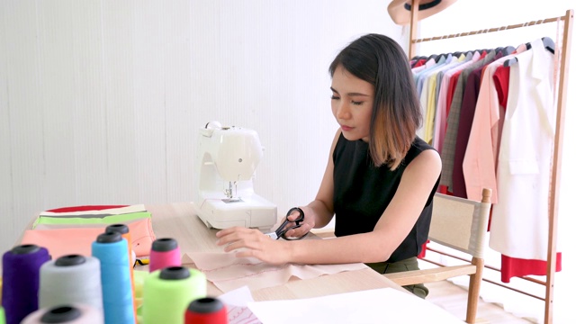 慢镜头，年轻时装设计师在缝纫工作室裁剪面料视频下载