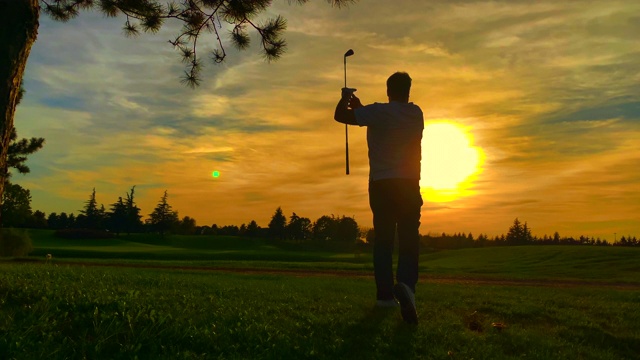 高尔夫球手与高尔夫挥杆对太阳在日落视频素材