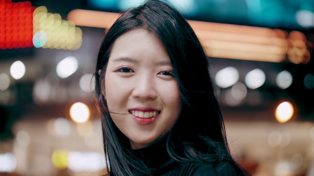 泰国年轻女子微笑，同时看着她的假日之夜旅行的相机视频下载