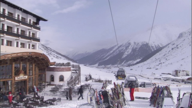 游客和滑雪者享受着一个下雪的度假胜地。视频素材