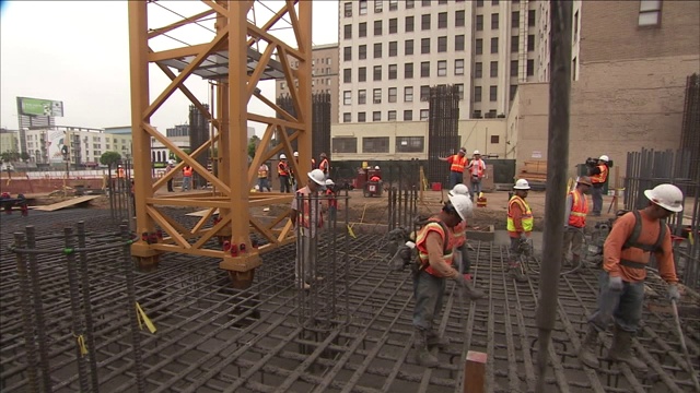 建筑工人用软管将水泥输送到钢筋地基上。视频素材
