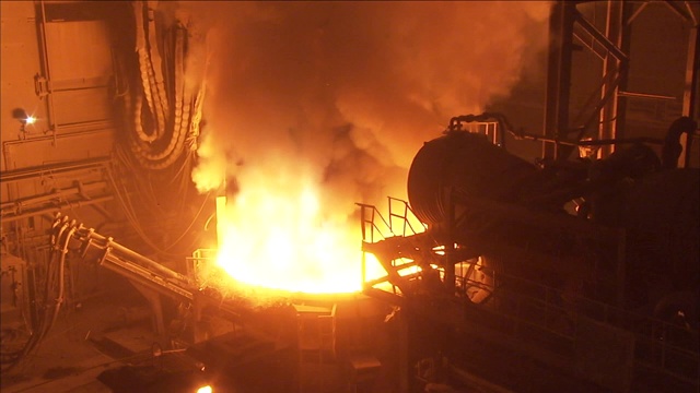 火焰和蒸汽从炼钢厂的熔炉中翻腾而出。视频素材