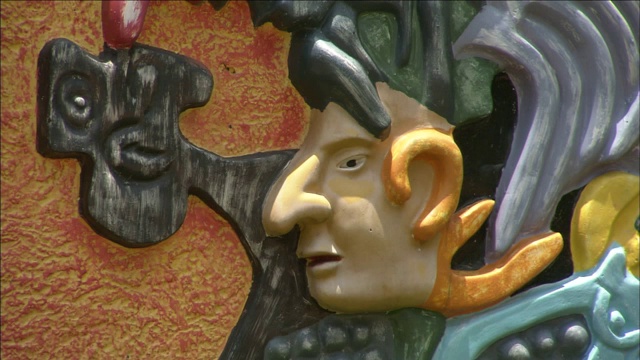 一幅彩色的玛雅浮雕描绘了一个穿着装饰服装的男人。视频下载