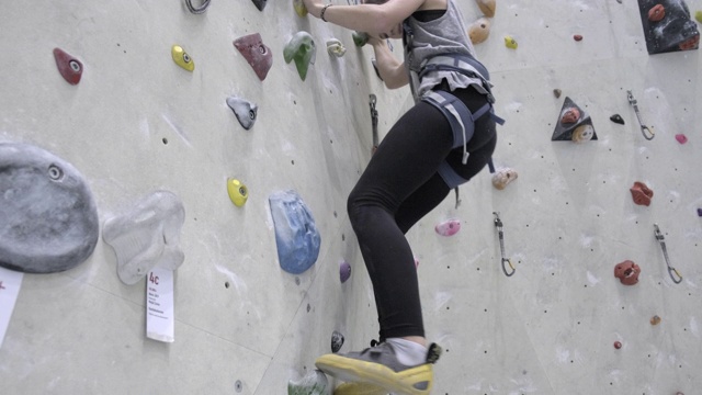 十几岁的女孩在爬室内攀岩墙视频素材