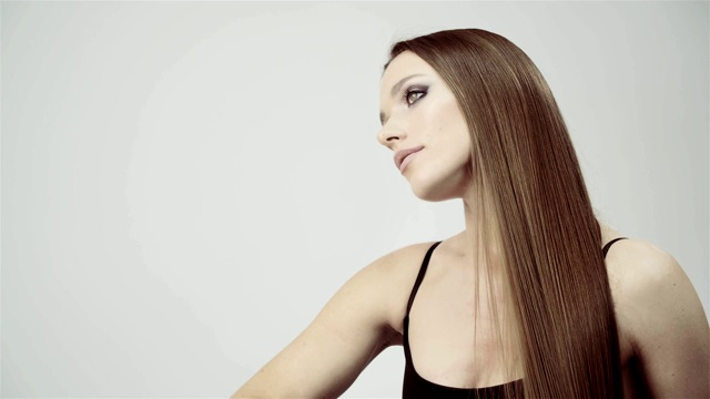 漂亮的女孩梳着她光滑的长发。头发护理产品。视频素材