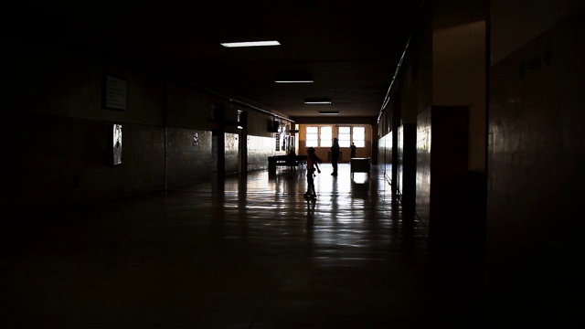 人们的剪影走过黑暗的走廊背光视图。视频素材