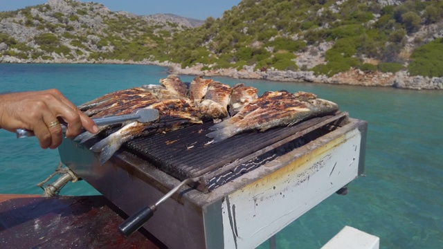 在土耳其的蓝色航行中在船甲板上烤鲈鱼视频下载