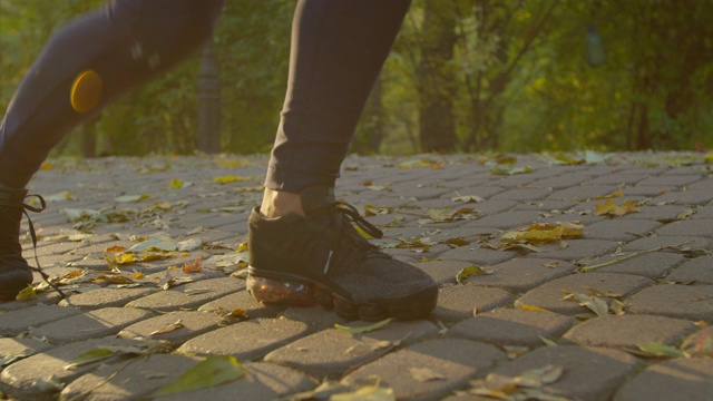 年轻的健身妇女在公园里系运动鞋跑步鞋带。视频素材