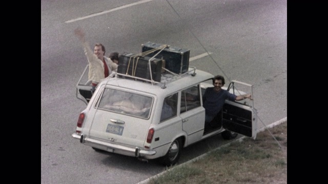 在美国新泽西州大西洋城的道路上，从汽车上倾斜的男人挥手的高角度视图视频下载