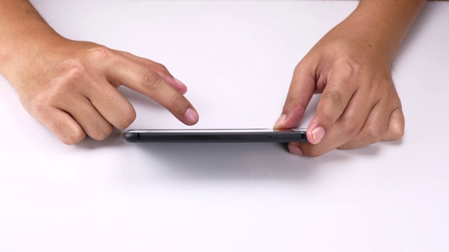 人的手在白色背景下握住手机的触摸屏。视频素材