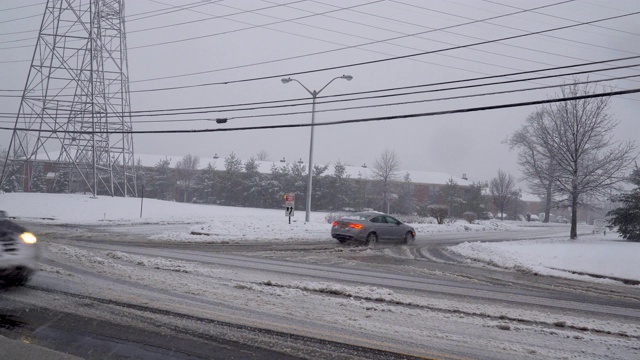 冬天，雪地里的汽车在一场暴风雪中行驶在路上视频素材