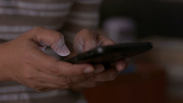靠近女人的手短信在移动智能手机上交流。视频素材