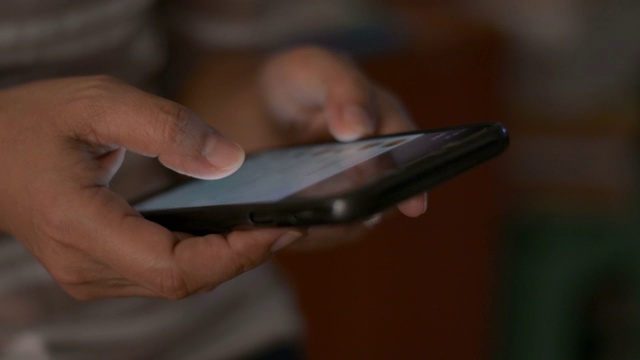 靠近女人的手短信在移动智能手机上交流。视频素材