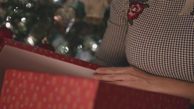 一个不认识的女人正在打开她的圣诞礼物视频下载
