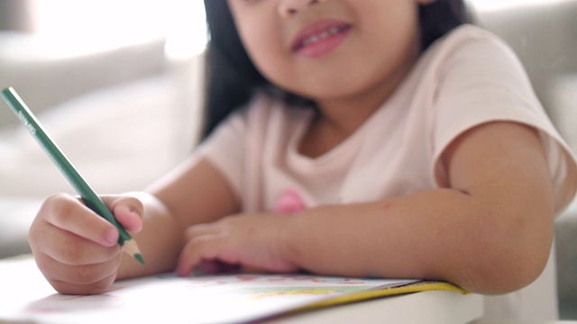 小女孩在家里的画册上写字，慢镜头视频素材