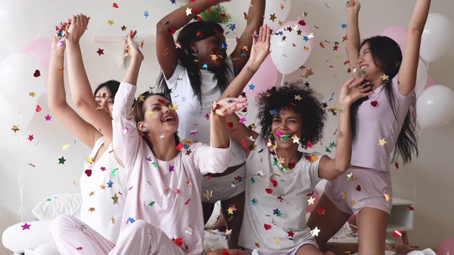 开心兴奋的年轻姑娘们穿着五彩纸屑庆祝睡衣派对视频素材
