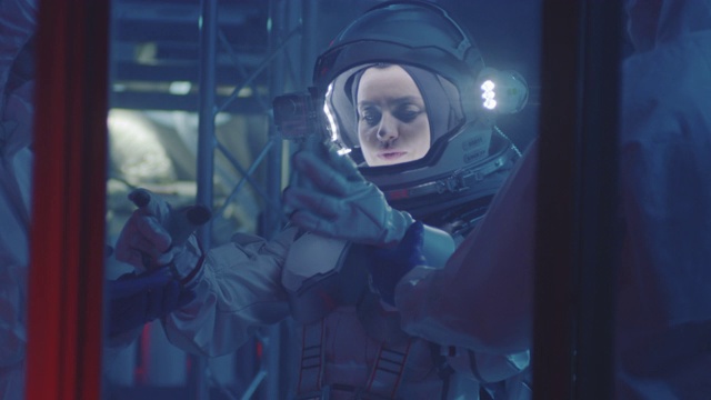 科学家帮助宇航员戴上手套视频素材
