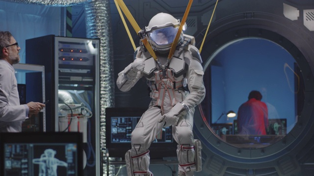 宇航员一边活动四肢，一边挂在带子上视频素材