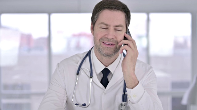 中年医生在办公室用智能手机说话的肖像视频素材