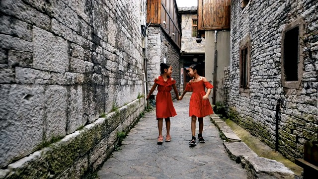 中国贵州安顺，小女孩们在一条老胡同里散步。视频购买
