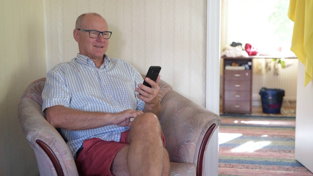 在家里沙发上玩手机的快乐老人视频下载