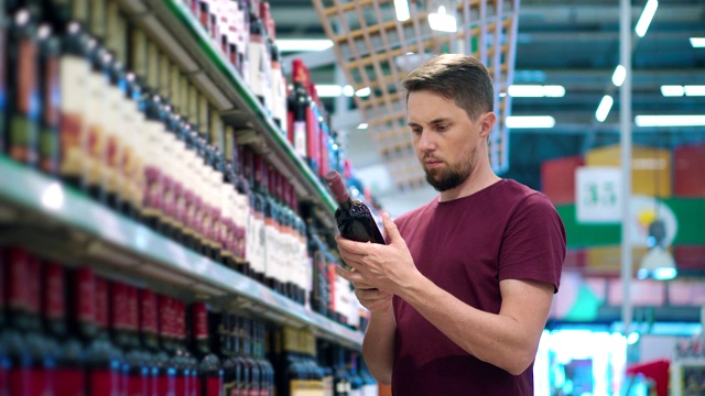 男士正在超市购物区挑选红酒视频下载