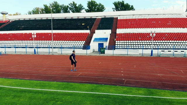 一个戴着仿生腿的人正沿着体育场走着视频素材
