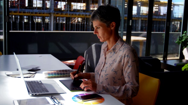 女性平面设计师在4k办公桌前使用平板电脑视频素材