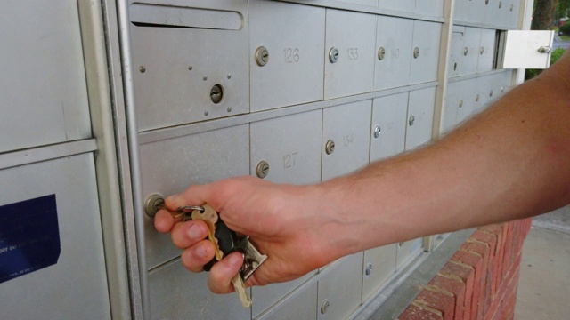 一个男人的手缓慢地从邮箱中取出一封信的特写。视频下载