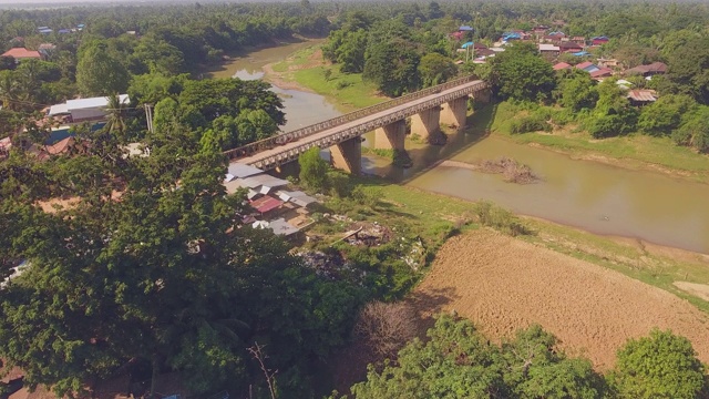连接两个小村庄的河流上的一座旧桥的缓慢无人机飞行视频素材
