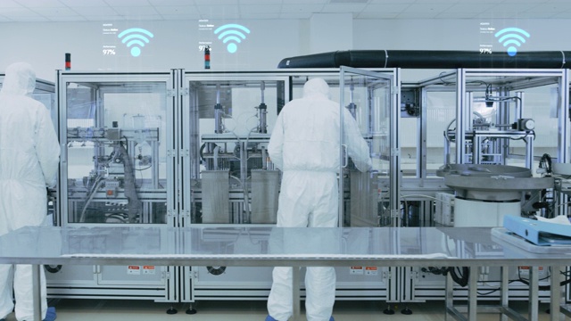 制造设备工人使用工业高精度机械组装产品。特效动画:Wi-Fi连接图标与完成进度视频素材