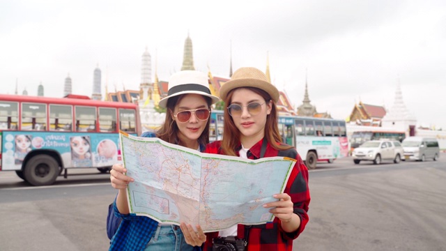 女人和朋友在看地图。亚洲女人享受在泰国唐人街旅游视频下载