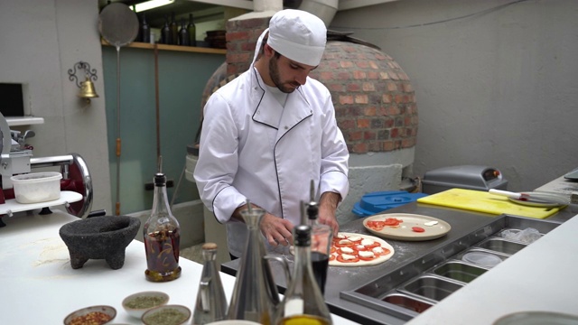 一位年轻的男厨师正在餐厅里准备那不勒斯披萨视频素材