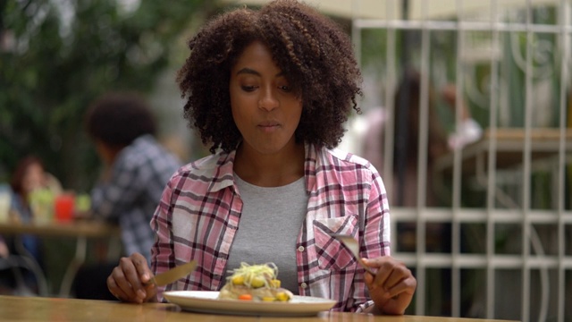 美丽的黑人妇女在餐厅享受美味的一餐视频下载