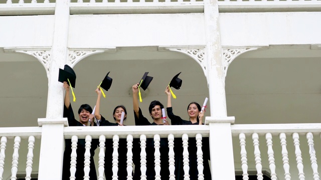 一群快乐的学生在毕业典礼上举起手臂。视频素材