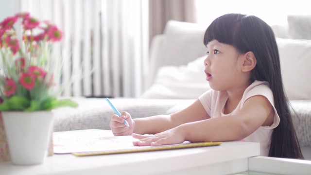 小女孩厌倦了家庭作业和在画册上写字视频素材