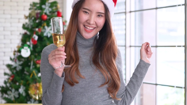 美丽的亚洲女人在圣诞晚会上跳舞并向镜头敬酒视频下载