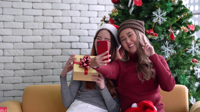 圣诞节期间，亚洲女性用手机展示礼物和自拍视频下载