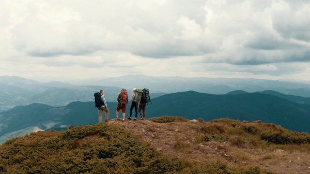 四个活跃的人站在一座山上视频素材